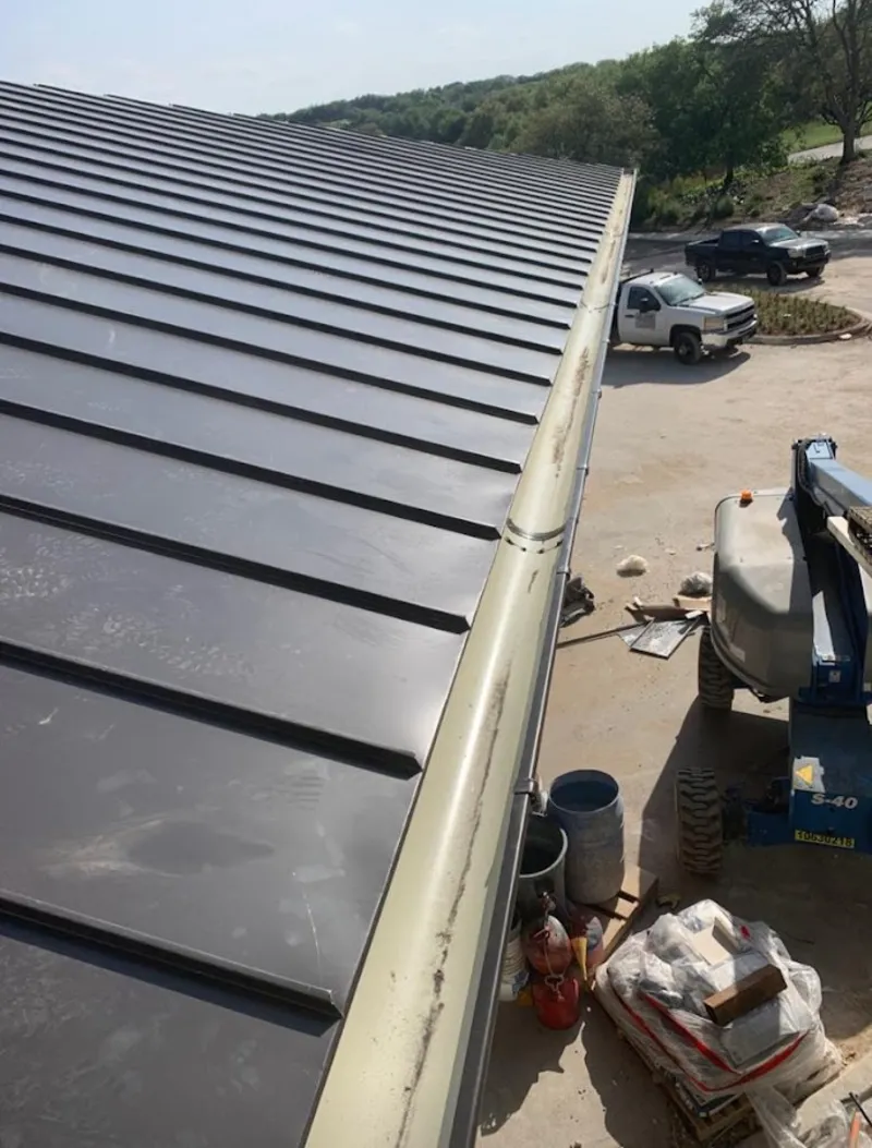 Standing seam panel and gutter detail on a metal roofing jobsite in Ellington